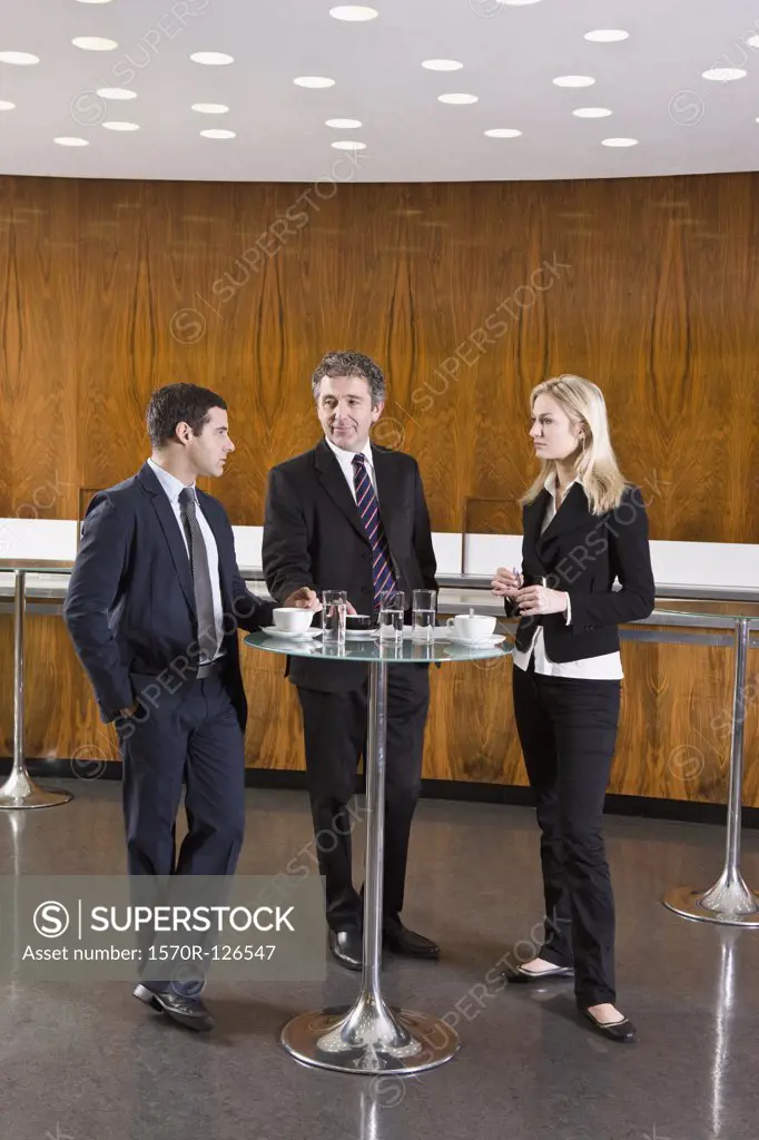 Three business people standing in a cafe