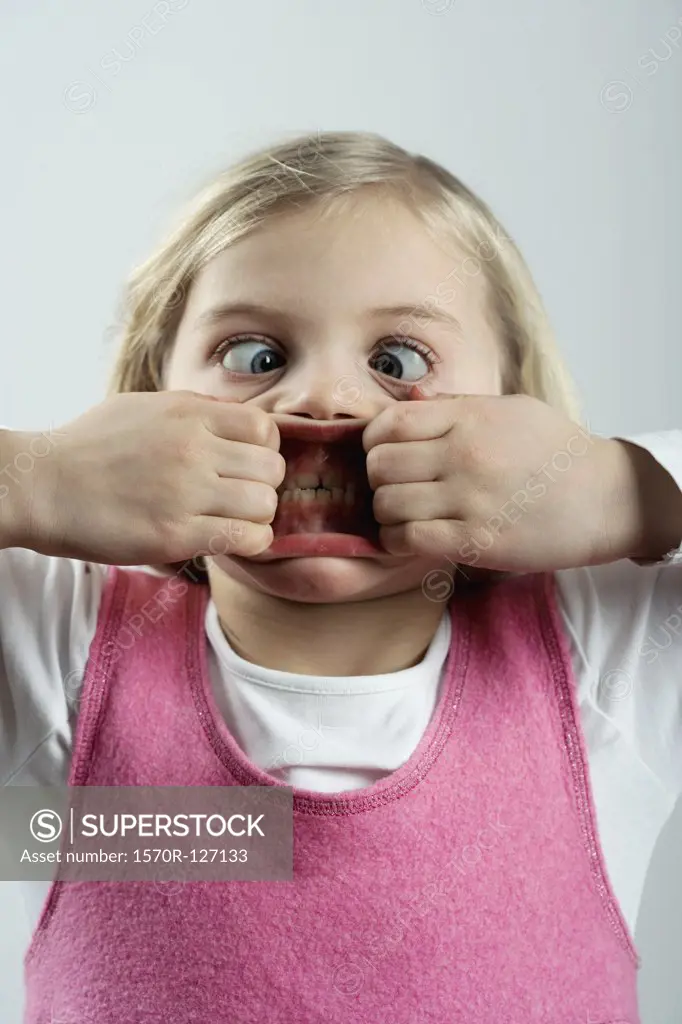 A little girl making a scary face