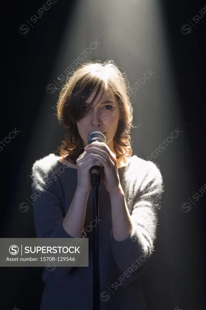 A Woman Standing Behind A Microphone