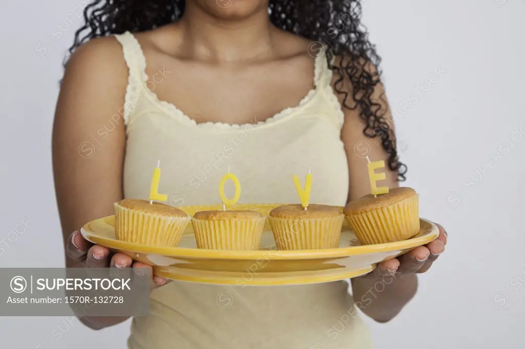 Detail of a woman holding cupcakes