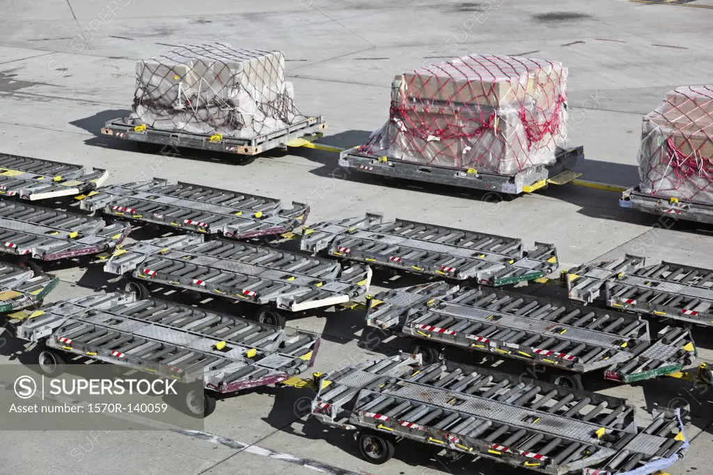 Empty baggage trailers and cargo on an airport tarmac