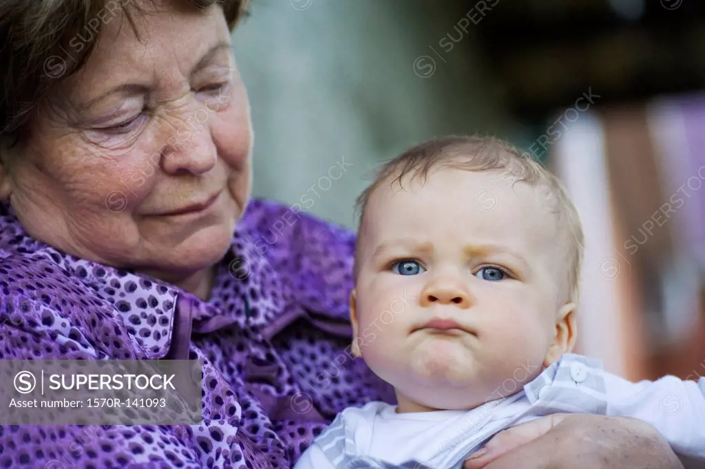 A senior woman holding a baby