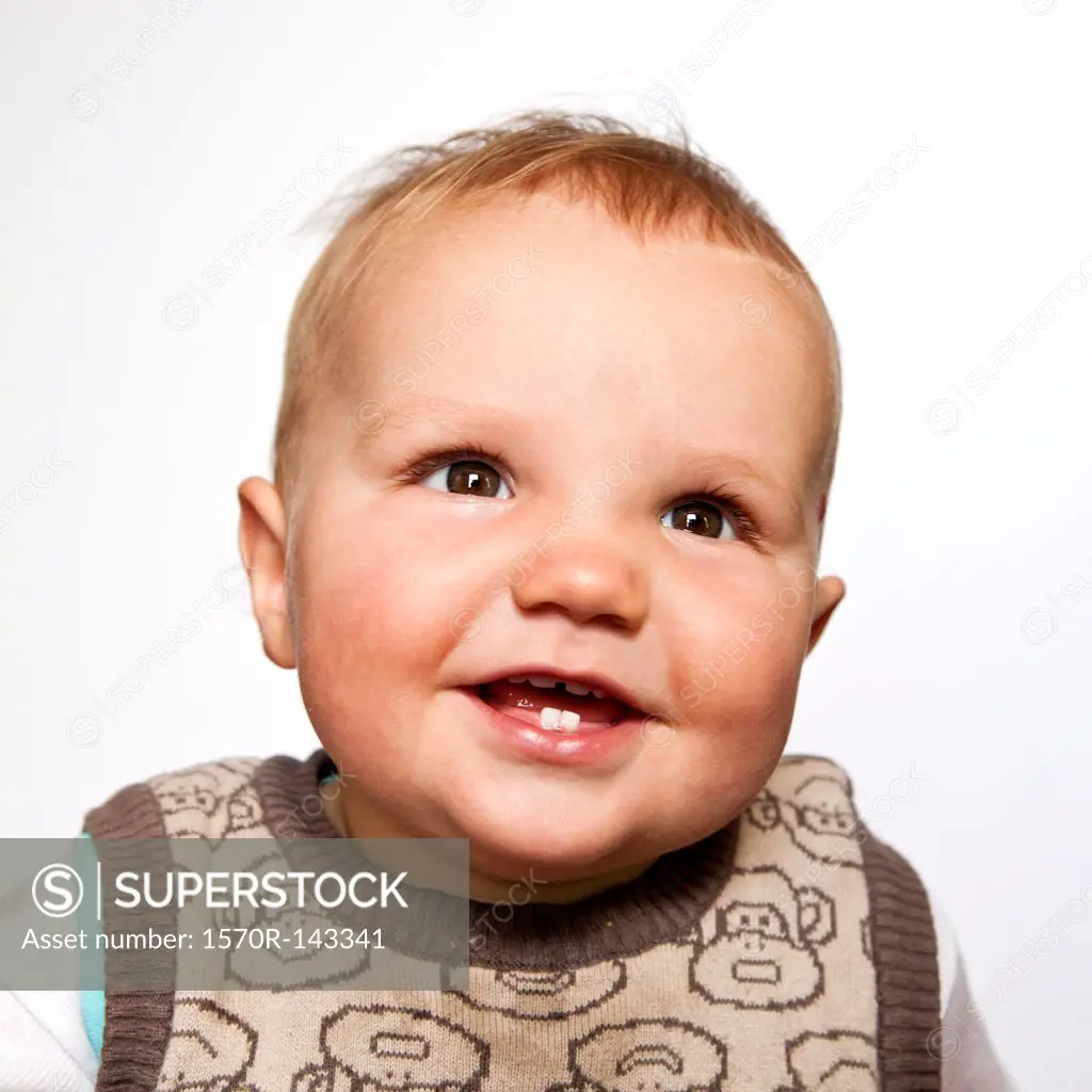 A baby boy looking up happily, head and shoulders portrait