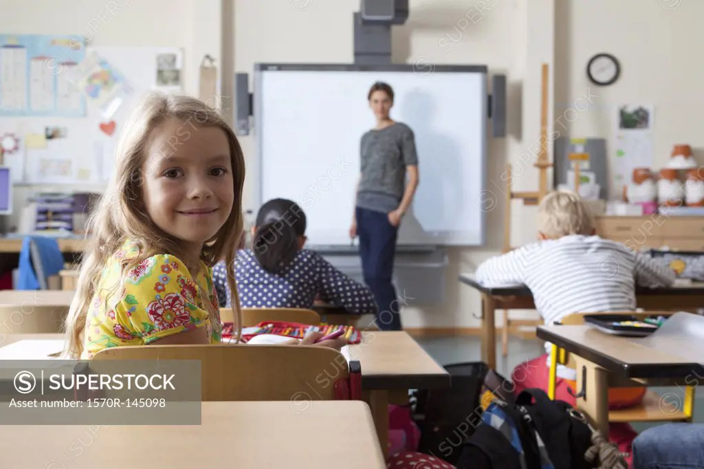 Girl sitting in classroom, smiling