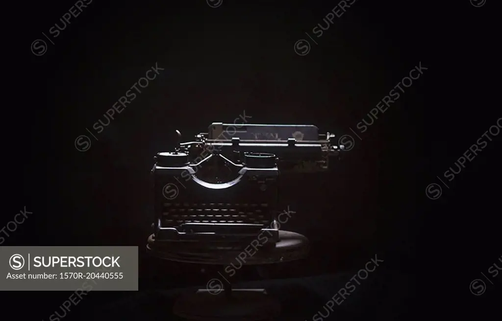 Typewriter on table against black background