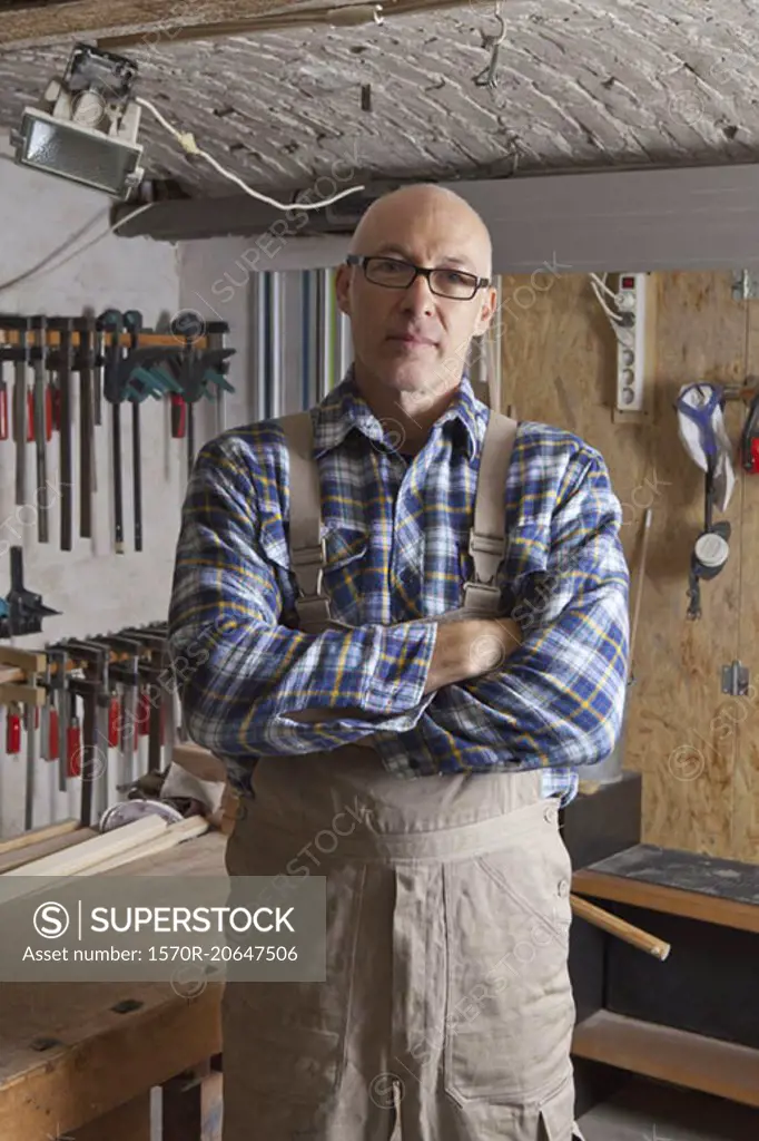 Mature man standing in carpenter shop, portrait