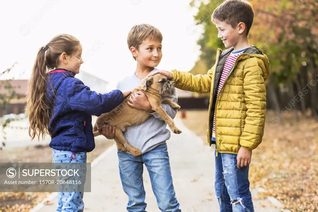 Children playing with dog outdoors