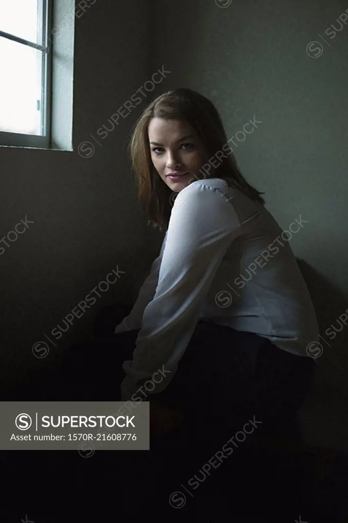 Portrait of beautiful woman sitting by window