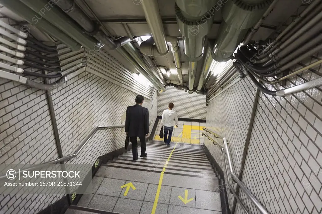 High angle view of people moving down on steps at subway station