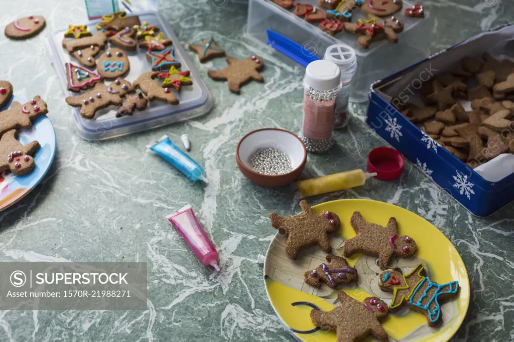 Various gingerbread cookies and decorating items on floor at home