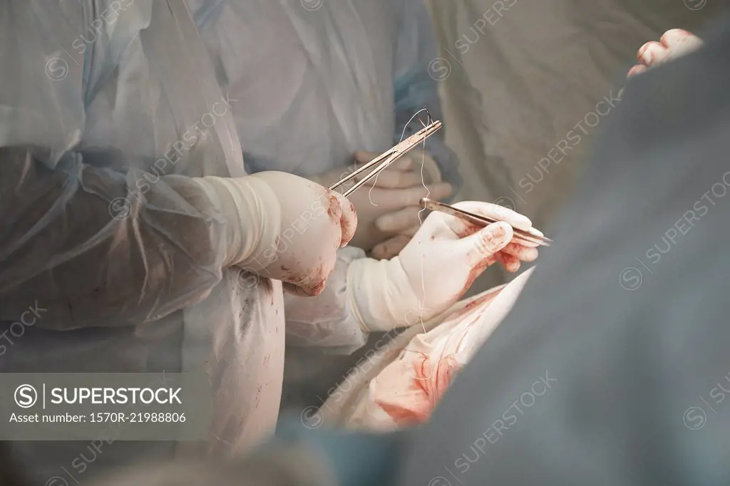 Midsection of medical team performing surgery in operating room