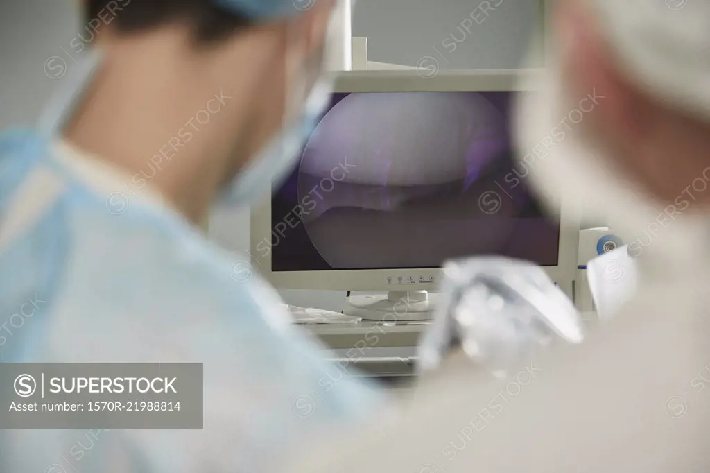 Male doctor looking at monitoring equipment in operating room