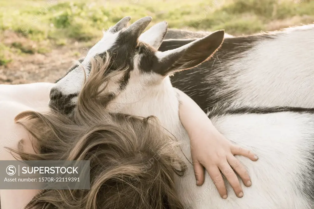 Girl hugging goat