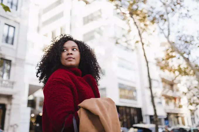 Young woman looking over shoulder on urban street