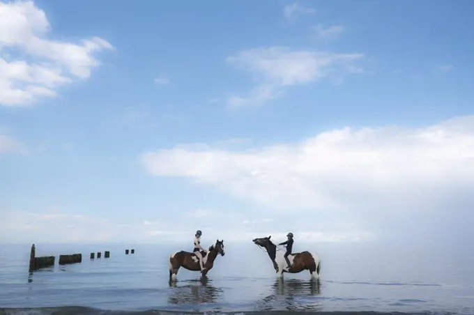 Girls riding horses in Baltic Sea, Germany