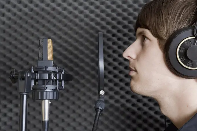 Man in sound booth of recording studio