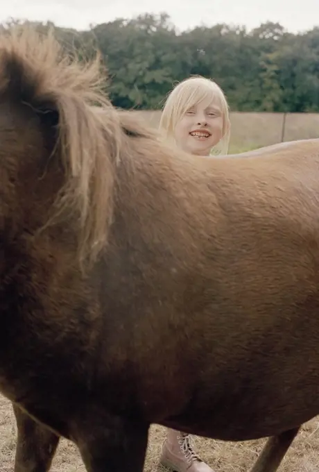 A girl standing behind a horse