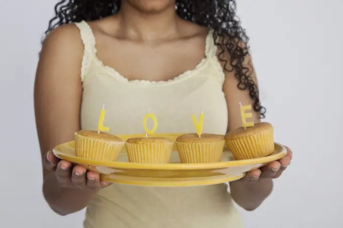 Detail of a woman holding cupcakes