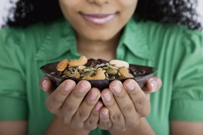 Detail of a woman holding a bowl of nuts