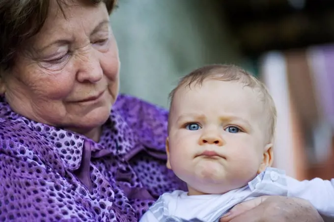 A senior woman holding a baby