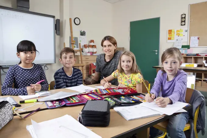 Teacher with students in classroom, portrait