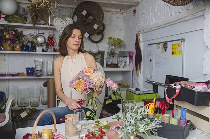 Female owner making flower bouquet at store