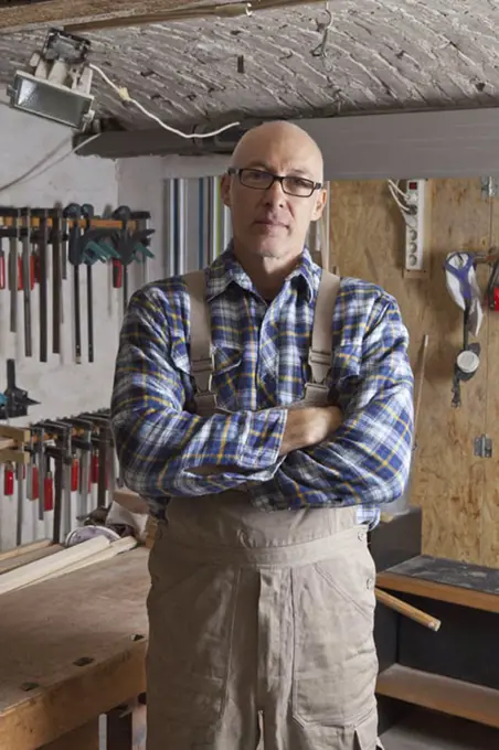 Mature man standing in carpenter shop, portrait