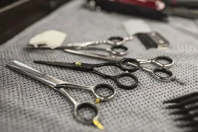 Close-up of various scissors on napkin at hair salon