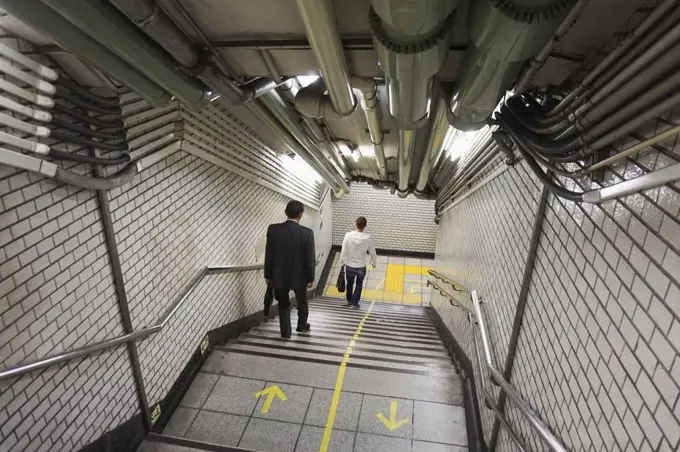 High angle view of people moving down on steps at subway station