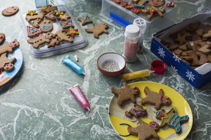 Various gingerbread cookies and decorating items on floor at home