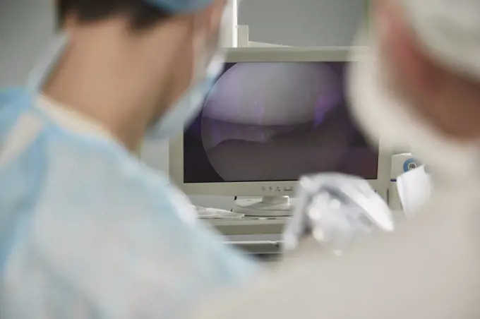 Male doctor looking at monitoring equipment in operating room