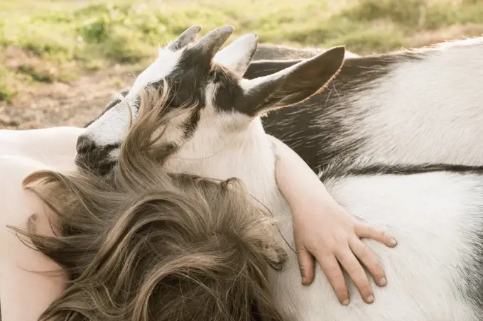 Girl hugging goat