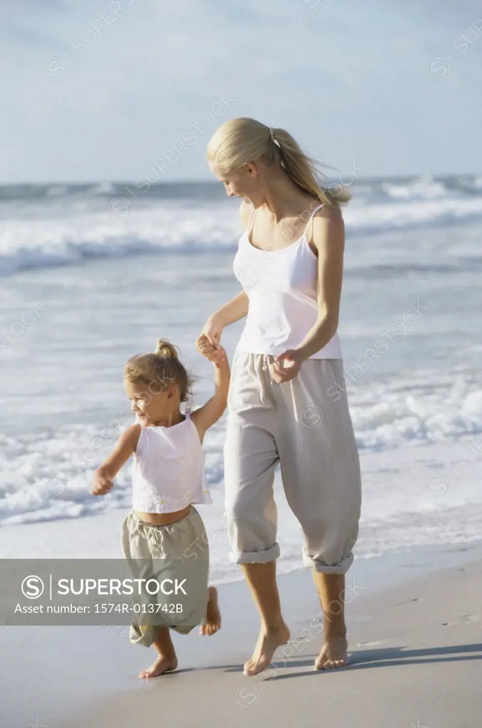 Mother and daughter walking on the beach