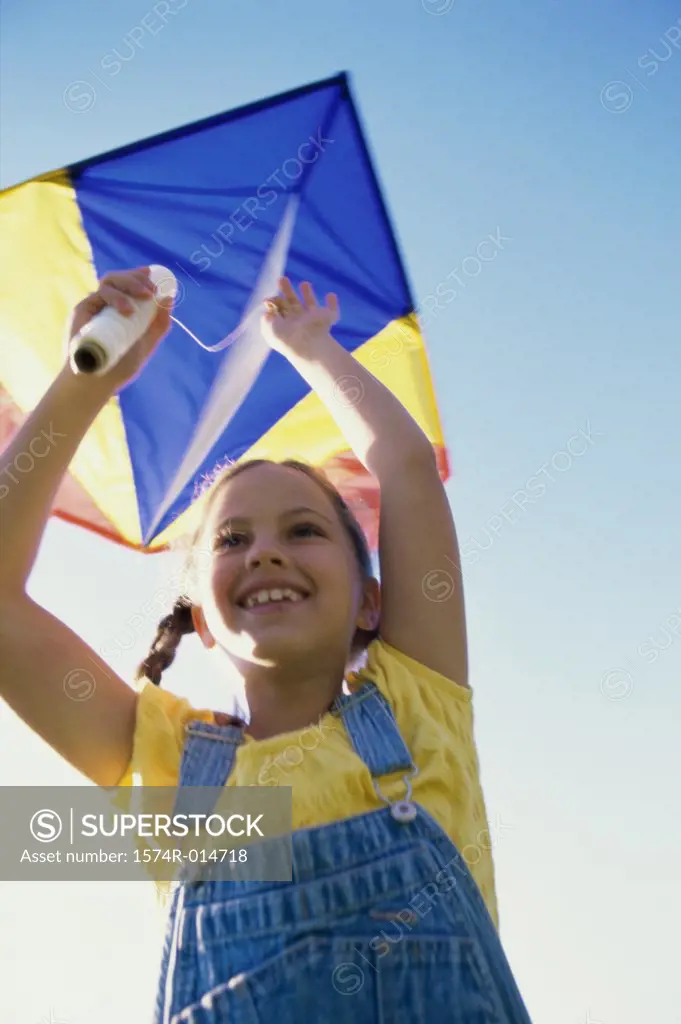 Low angle view of a girl flying a kite