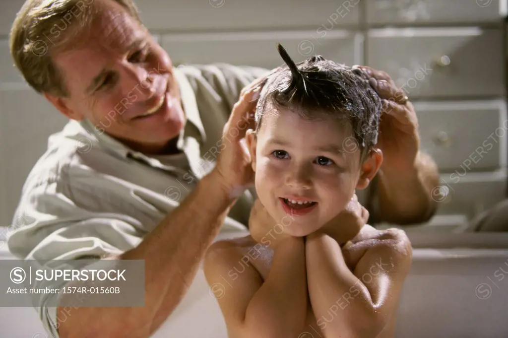 Close-up of a man shampooing his son's hair