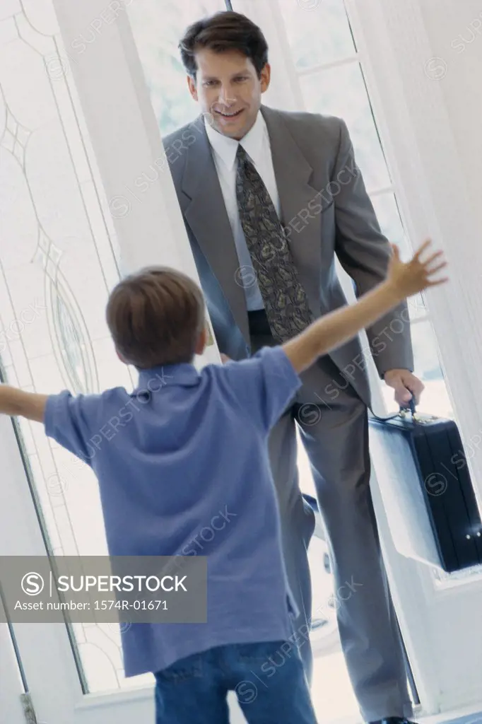 Boy greeting his father at the door