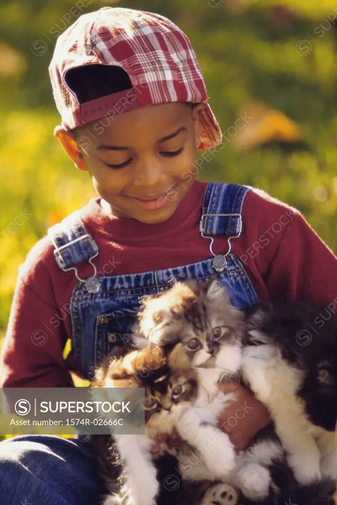 Portrait of a boy holding cats