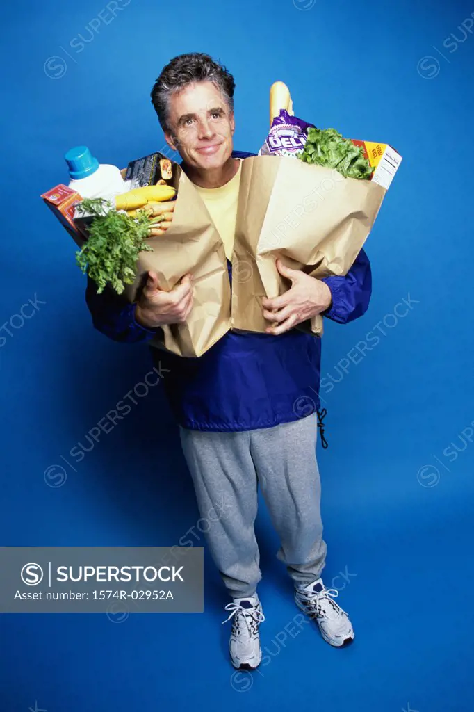 Mature man carrying two grocery bags