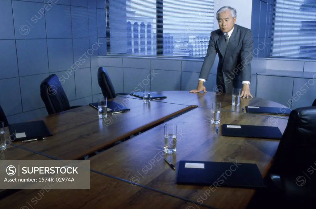 Businessman leaning on a conference table