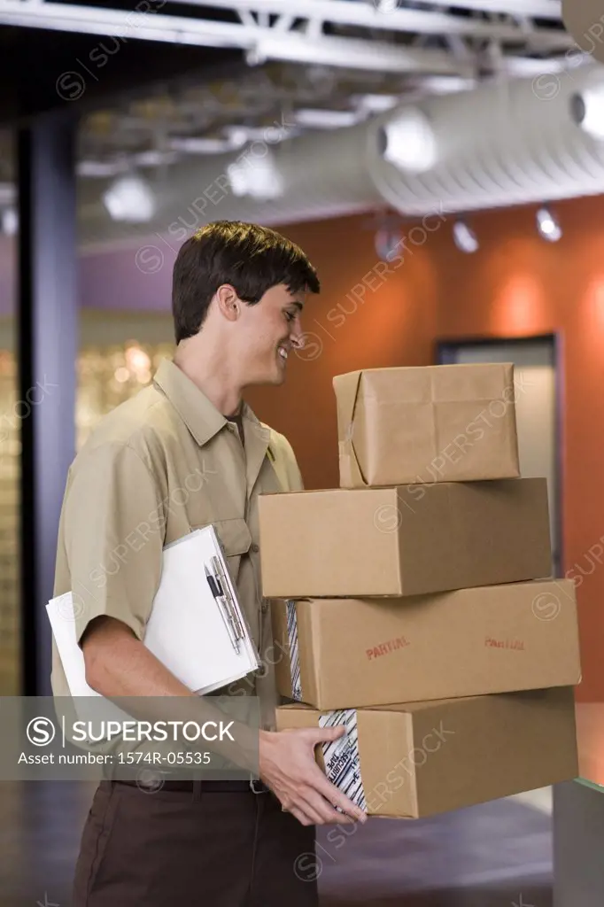 Side profile of a delivery man holding a stack of boxes