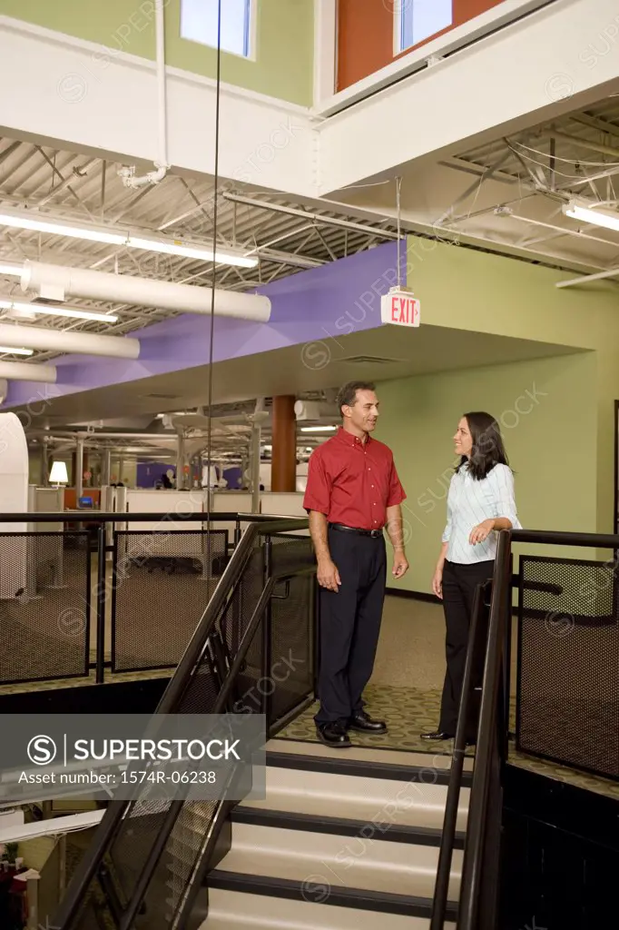 Businessman and a businesswoman standing on stairs