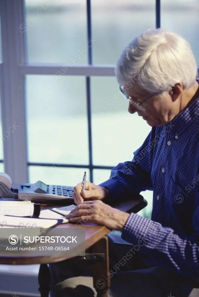 Senior man writing a check