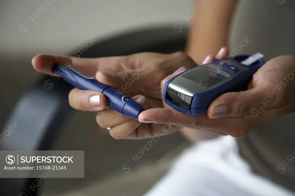 Close-up of a woman taking a blood sample from her finger with a glaucometer