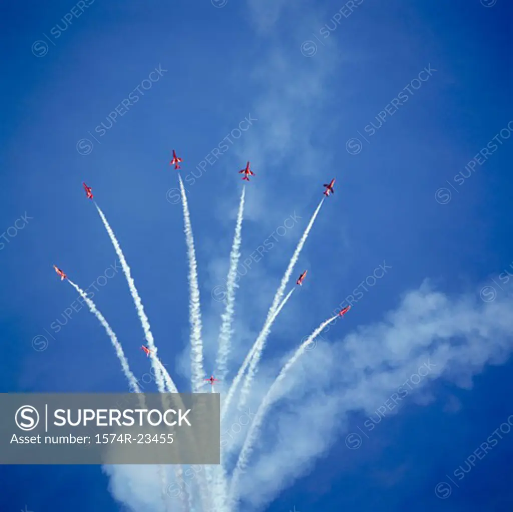 Low angle view of fighter planes performing aerobatics in sky, Red Arrows, Royal Air Force, England