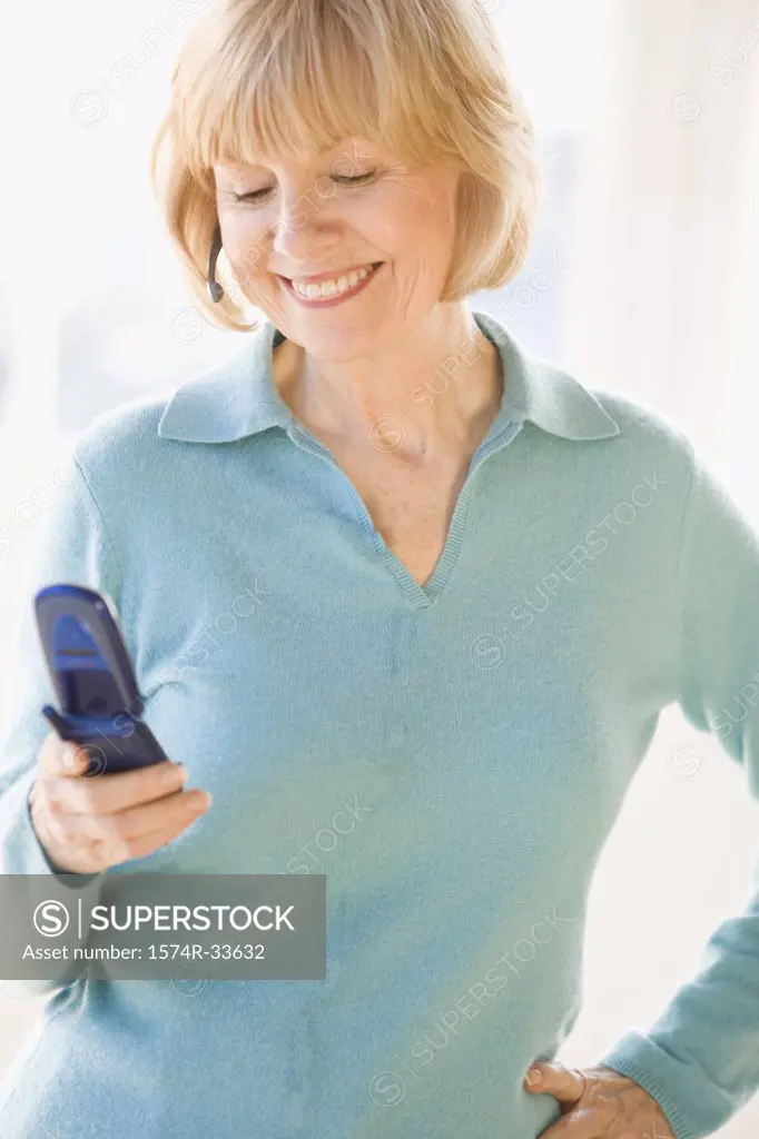 Businesswoman operating a mobile phone and smiling