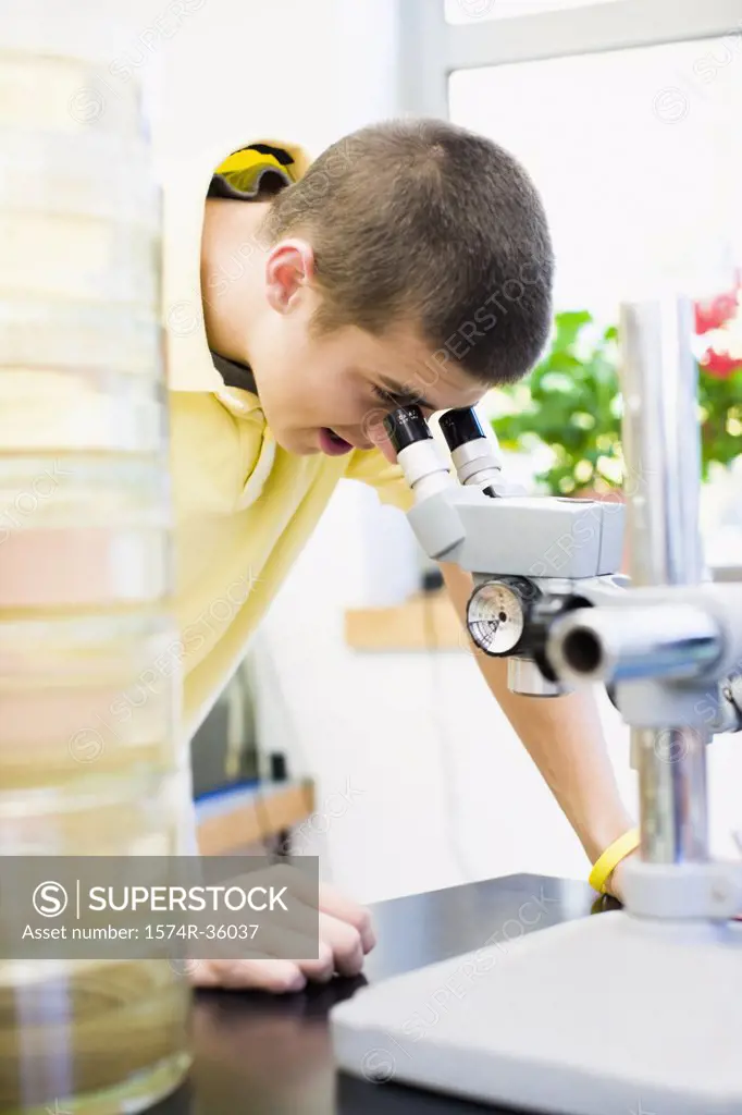 Student looking through a microscope in a laboratory