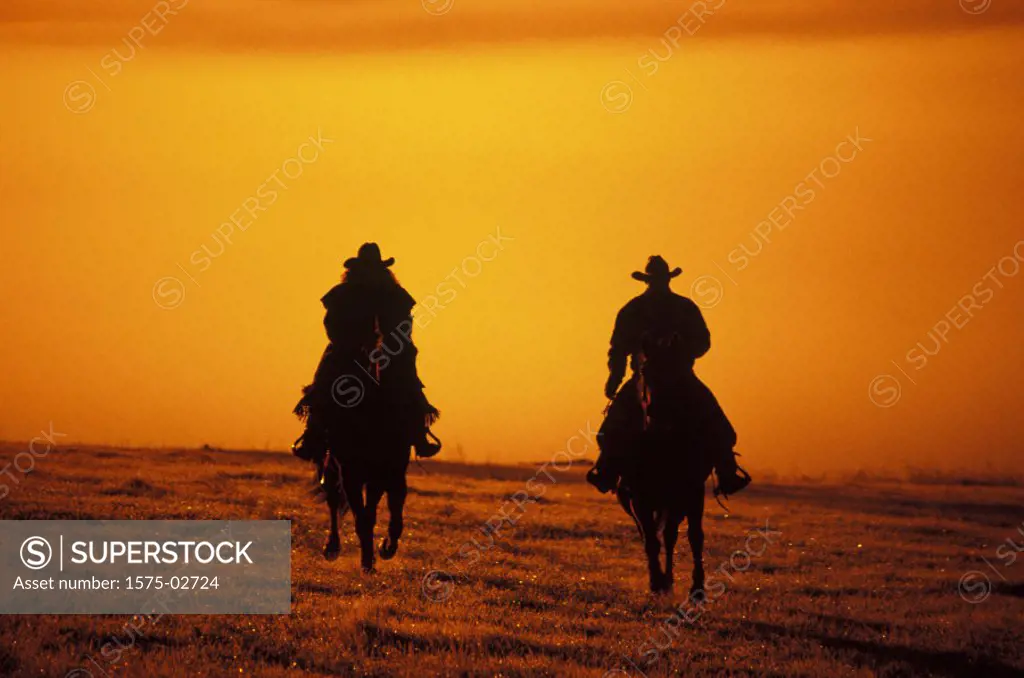 Silhouette of cowboy & cowgirl, Douglas Lake Ranch, British Columbia, Canada´