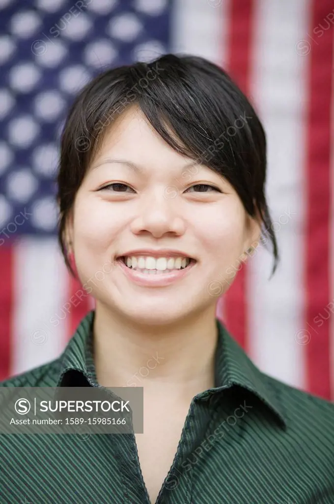 Asian woman standing near American flag