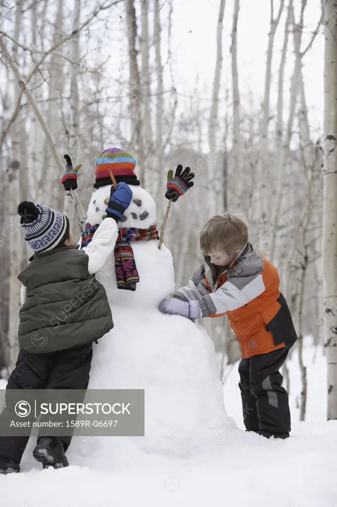 Two boys making a snowman