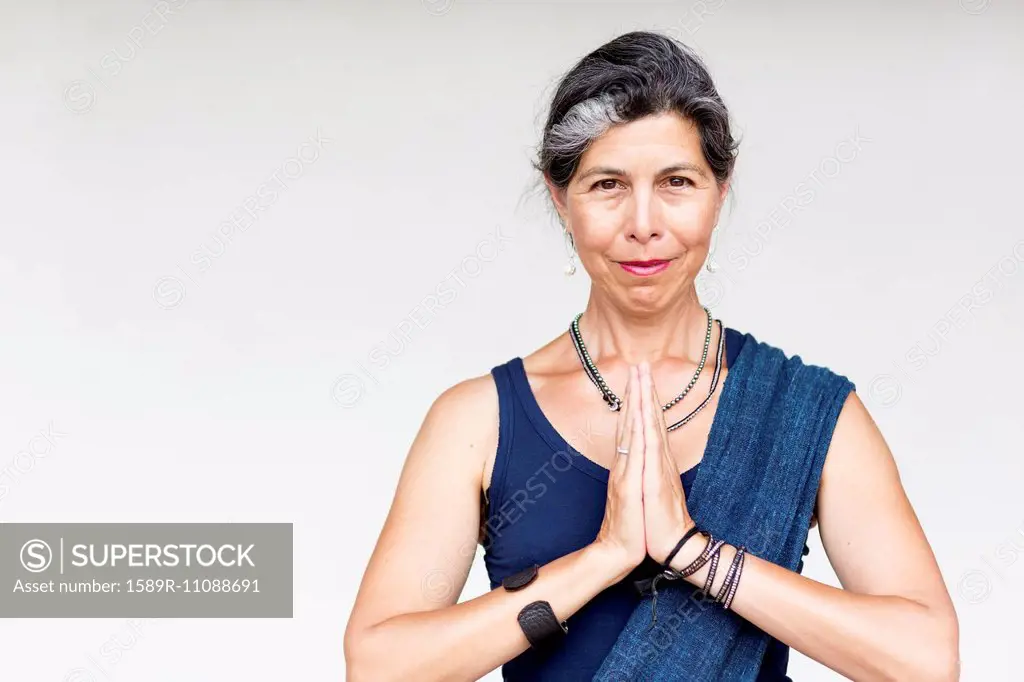 Older Hispanic woman with hands clasped